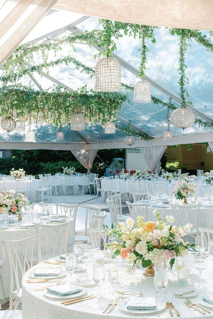 the tables are set with white linens and floral centerpieces