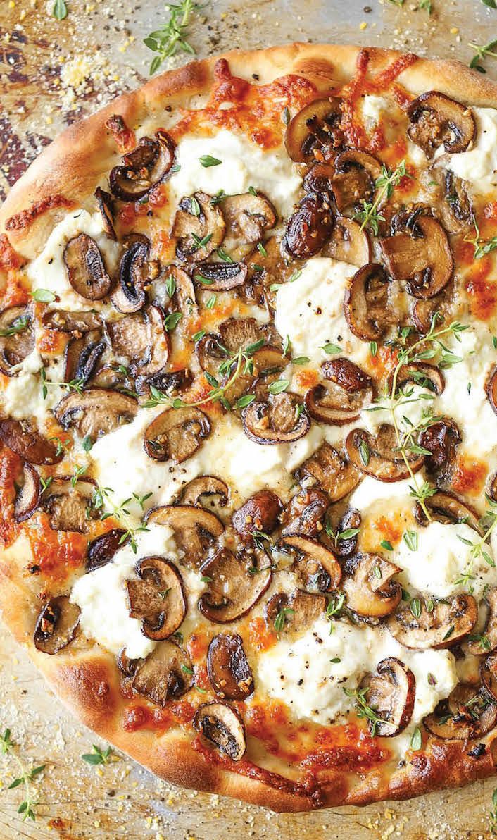 a pizza topped with mushrooms and cheese on top of a table