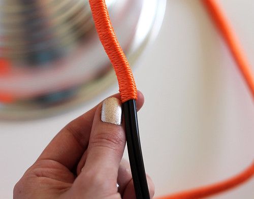 a person holding an orange string with black tips