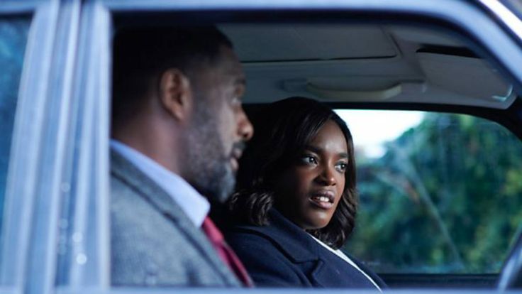 a man and woman sitting in the back seat of a car looking at each other