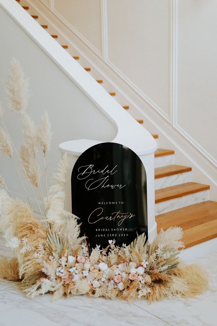 a black and white sign sitting on top of a table next to a stair case