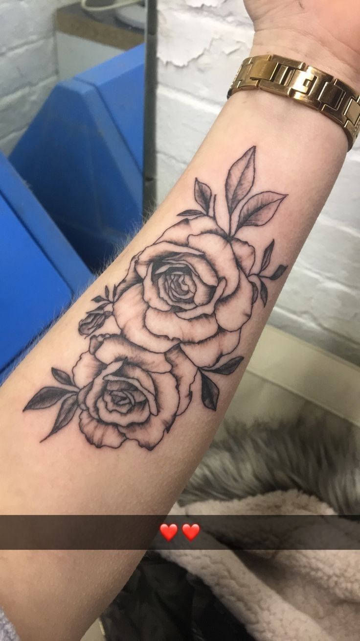 a black and white rose tattoo on the arm