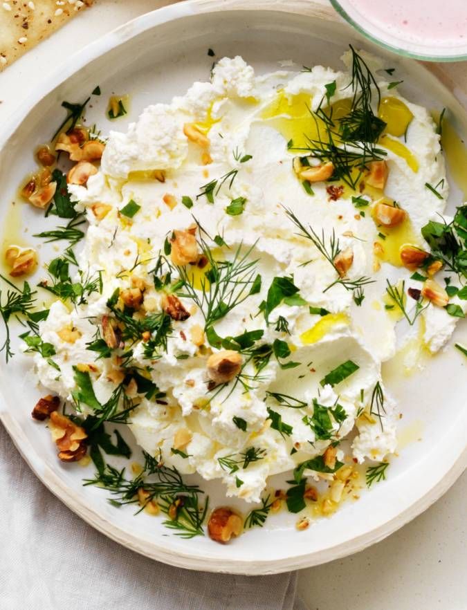 a white plate topped with lots of food on top of a table next to bread