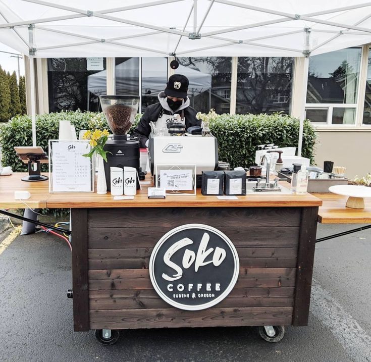 an outdoor coffee stand with various items on it