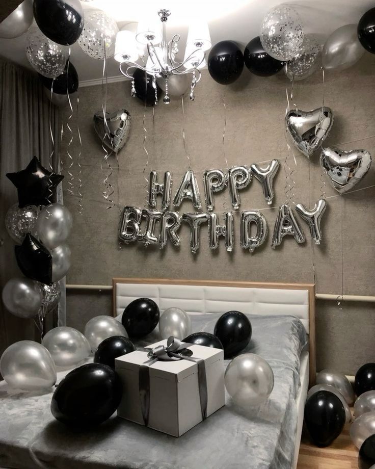 a bedroom decorated with balloons and black and silver decorations