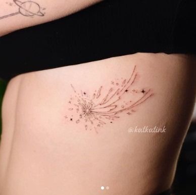 a woman's stomach with a dandelion tattoo on her left side belly