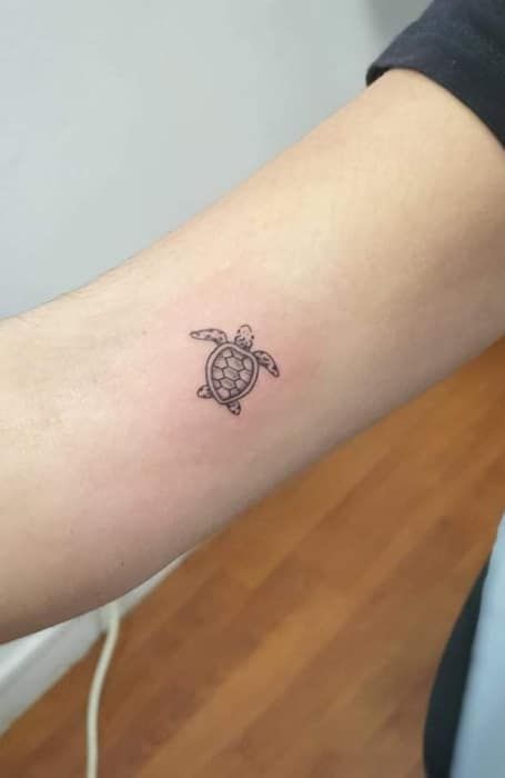 a small turtle tattoo on the arm