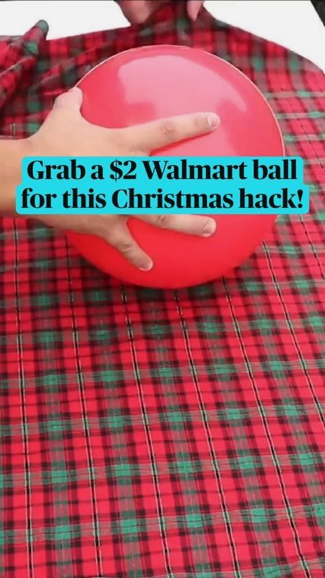 a person holding a red ball on top of a plaid table cloth with the words grab a $ 2 walmart ball for this christmas hack