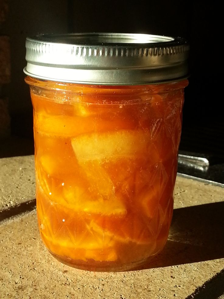 a jar filled with oranges sitting on top of a table