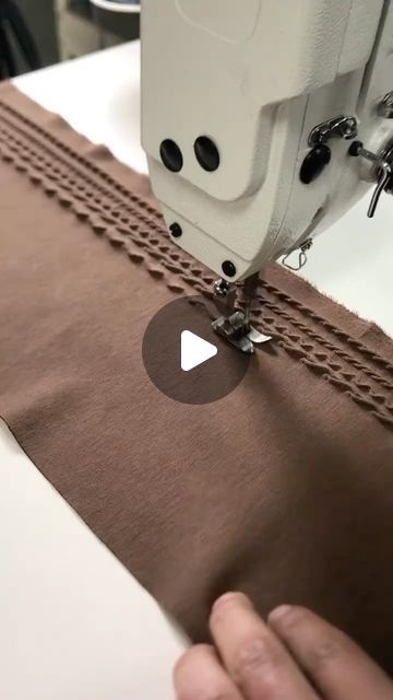 someone is using a sewing machine to sew fabric on the edge of a piece of cloth