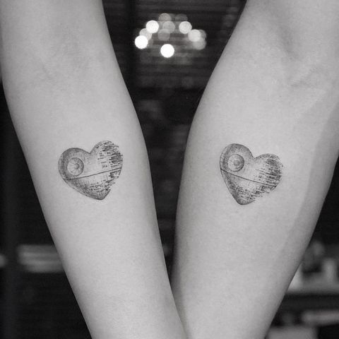 two people with tattoos on their arms are holding each other's hands and one has a map in the shape of a heart