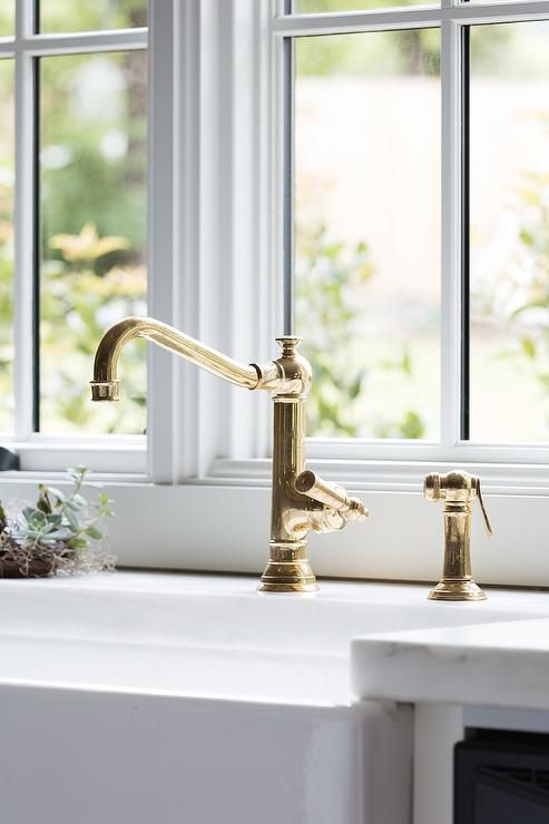 two faucets are sitting on the window sill in front of a sink