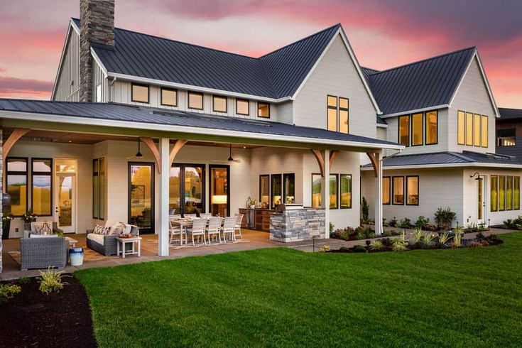 a large white house sitting on top of a lush green field