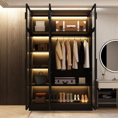 an open closet with clothes and shoes on the shelves next to a vanity, mirror and dressing table