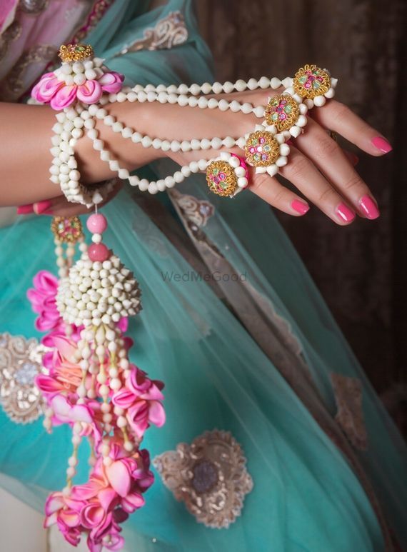 a close up of a person wearing pearls and bracelets