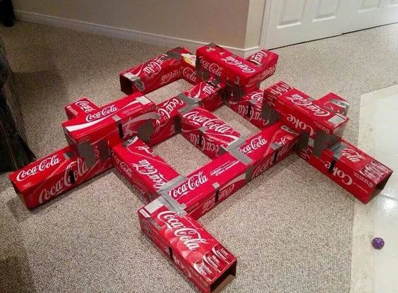 a pile of coca - cola boxes sitting on the floor