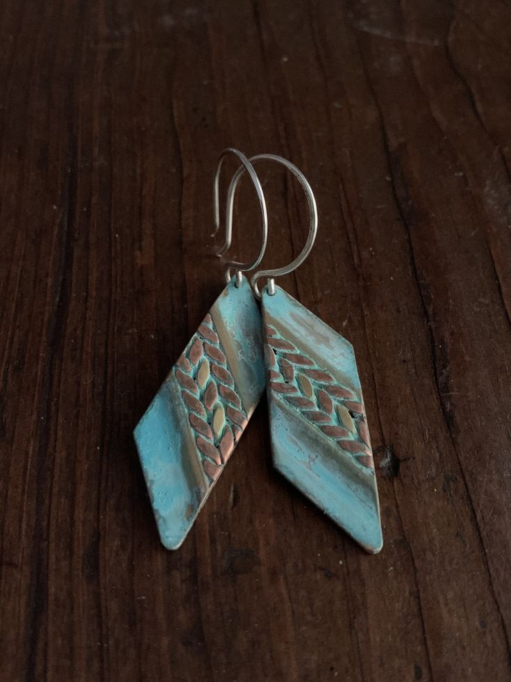 These earrings feature mixed metals of solid, gold brass & raw copper and are finished with a unique turquoise verdigris patina. The patina has been sealed with a good coating of renaissance wax but should not be worn while showering or bathing to maintain patina. The ear wires are forged by hand from 20g Sterling silver. These earrings have a celtic / tribal feel. They are versatile and suitable for just about any style, from modern to rustic. They're substantial but comfortable to wear. Th Blue Artisan Copper Earrings, Artisan Blue Copper Earrings, Earthy Copper Jewelry For Festivals, Hammered Bronze Jewelry For Festivals, Handmade Southwestern Copper Jewelry, Bohemian Electroformed Bronze Jewelry, Bohemian Bronze Electroformed Jewelry, Adjustable Bohemian Patina Earrings, Unique Blue Copper Earrings