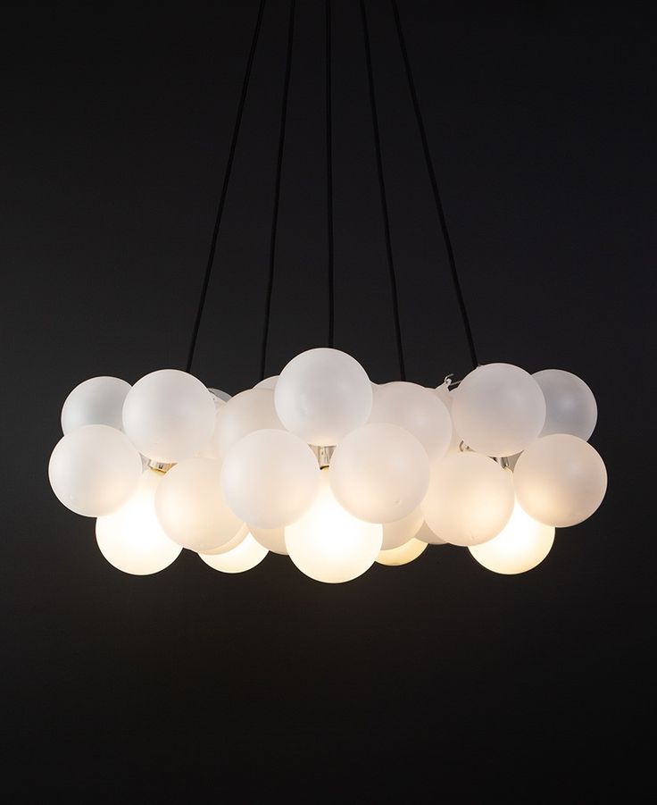 a chandelier with many white balloons hanging from it