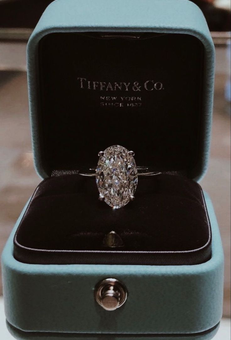 a diamond ring in a blue box with the words tiffany & co written on it