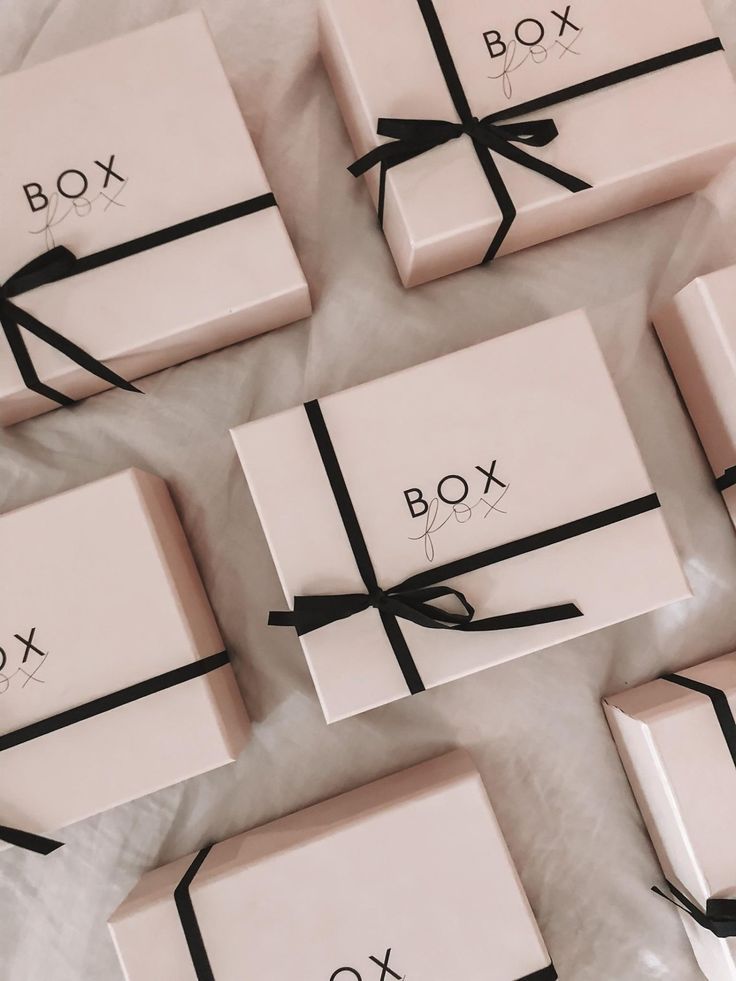 six pink boxes with black ribbons tied around them