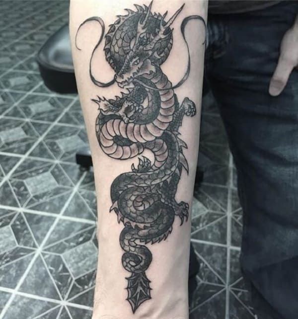 a black and white dragon tattoo on the arm