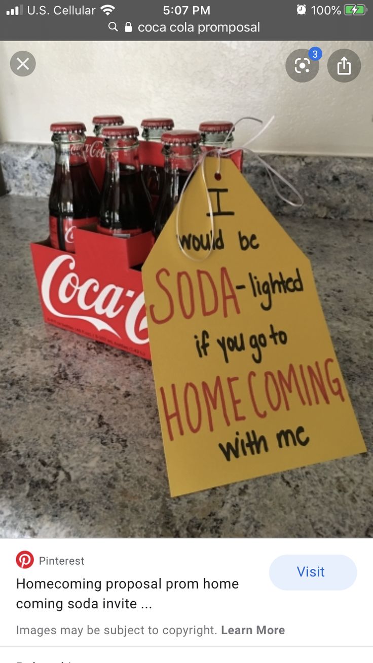 a sign that is sitting on top of a counter next to some soda bottles and a red box