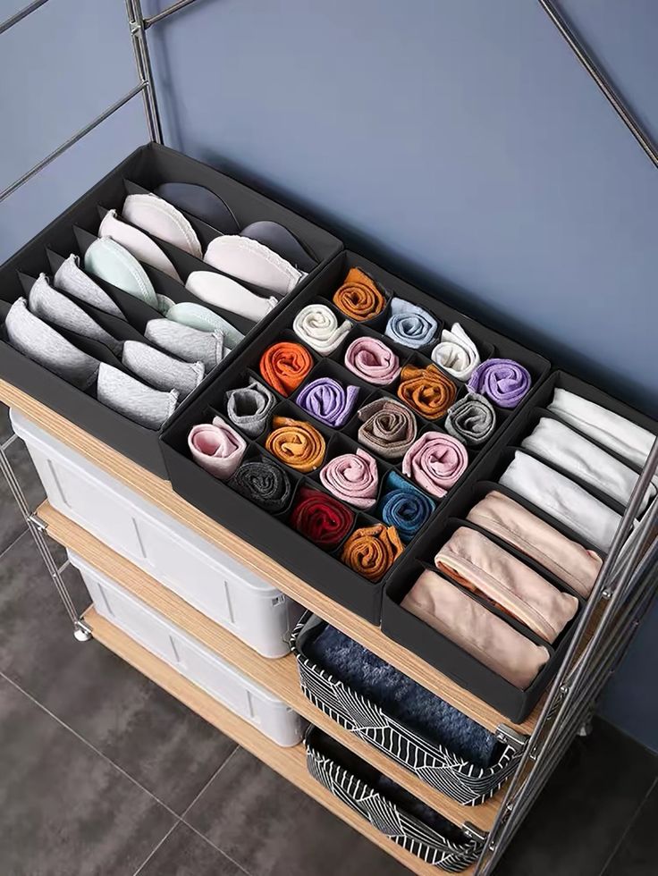 an organized drawer is shown with folded clothes and socks on it's trays