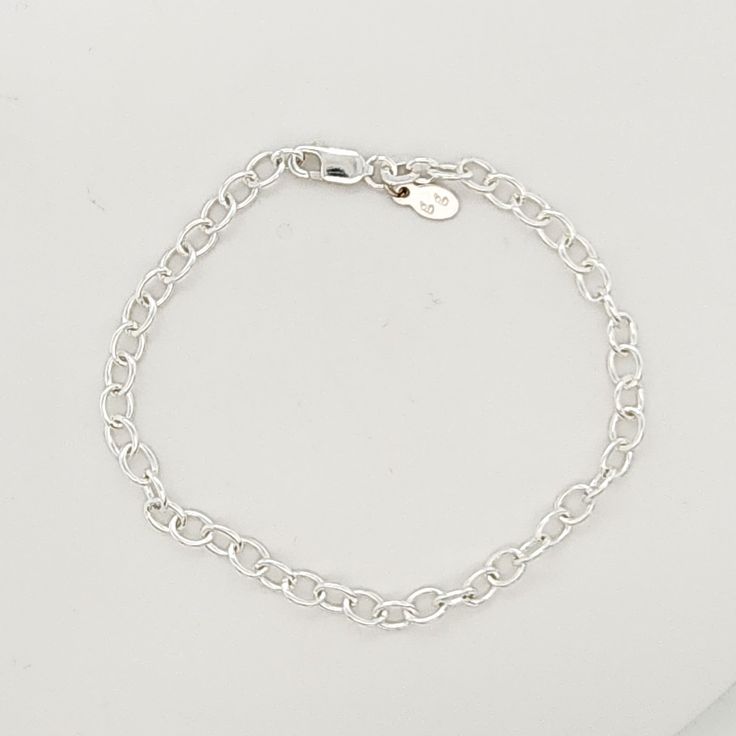 This Silver Charm Bracelet is a stylish and versatile accessory for women. Made of high-quality .925 sterling silver, this bracelet adds a touch of elegance to any outfit. With its simple yet eye-catching design, it is perfect for everyday wear or special occasions. Enhance your style with this must-have piece. The bracelet is 7" long, and charms are sold separately. Classic Silver Chain Charm Bracelet, Classic Silver Chain Bracelet For Everyday, Classic White Gold Charm Bracelet With Silver Chain, Classic Silver Chain Charm Bracelet With Oval Links, Classic Silver Chain Bracelet, Classic Silver Charm Bracelet For Everyday, Classic Bracelet With Sterling Silver Clasp As Gift, Elegant Sterling Silver Bracelet With Extender For Everyday, Sterling Silver Bracelet With Silver Chain For Everyday Wear