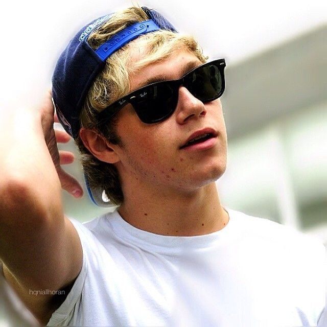 a young man wearing sunglasses and a baseball cap