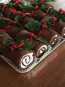 chocolate roll decorated with holly leaves and red berries on a platter for christmas desserts