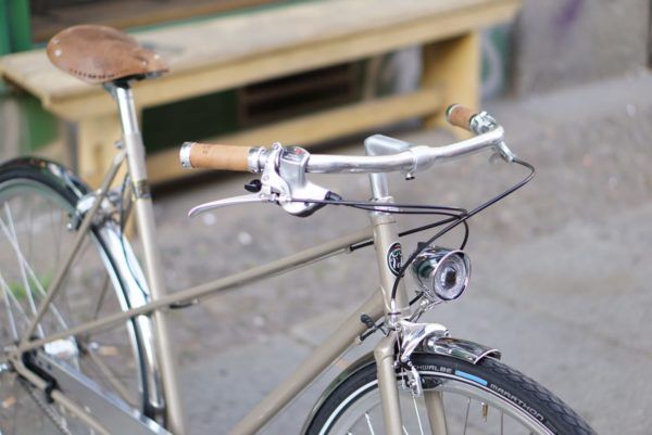 a silver bicycle parked next to a wooden bench