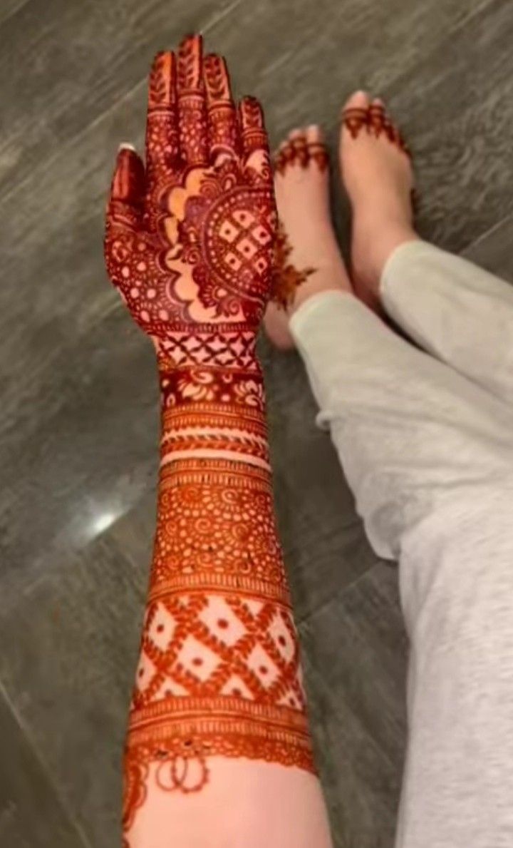 a woman's hand with henna on it and the bottom half of her arm