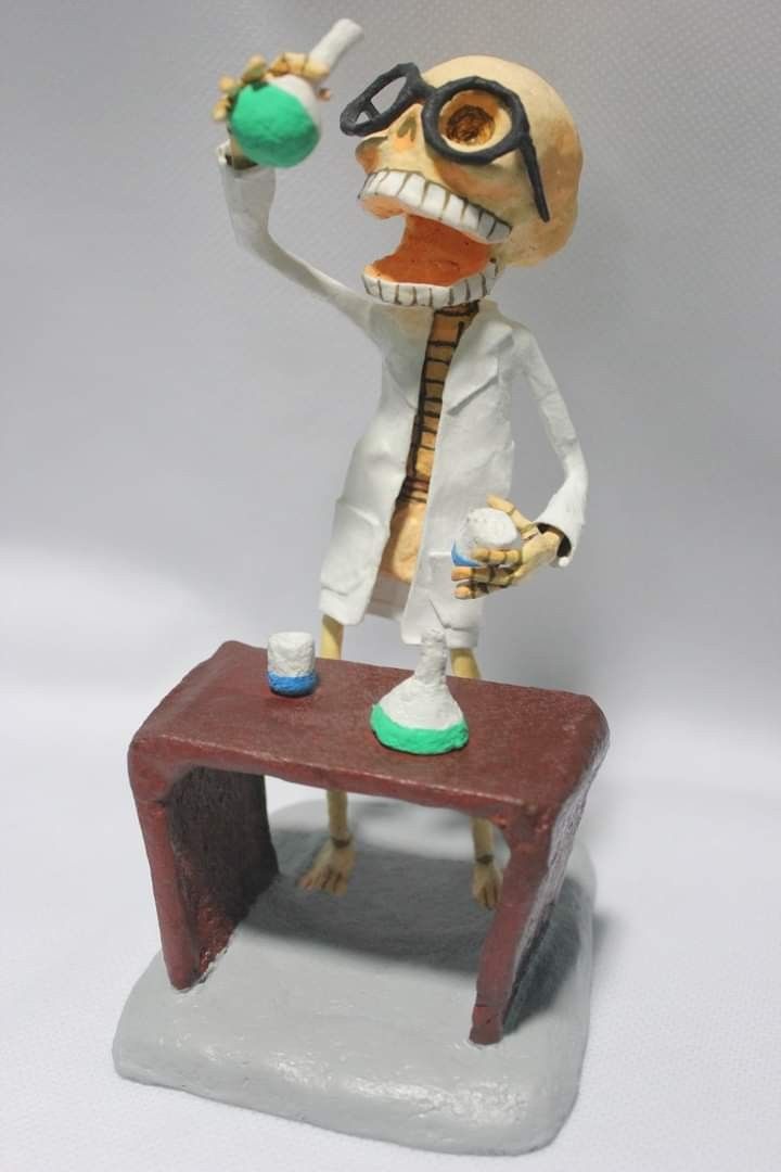 a figurine of a skeleton holding a beak and mixing liquid on a table