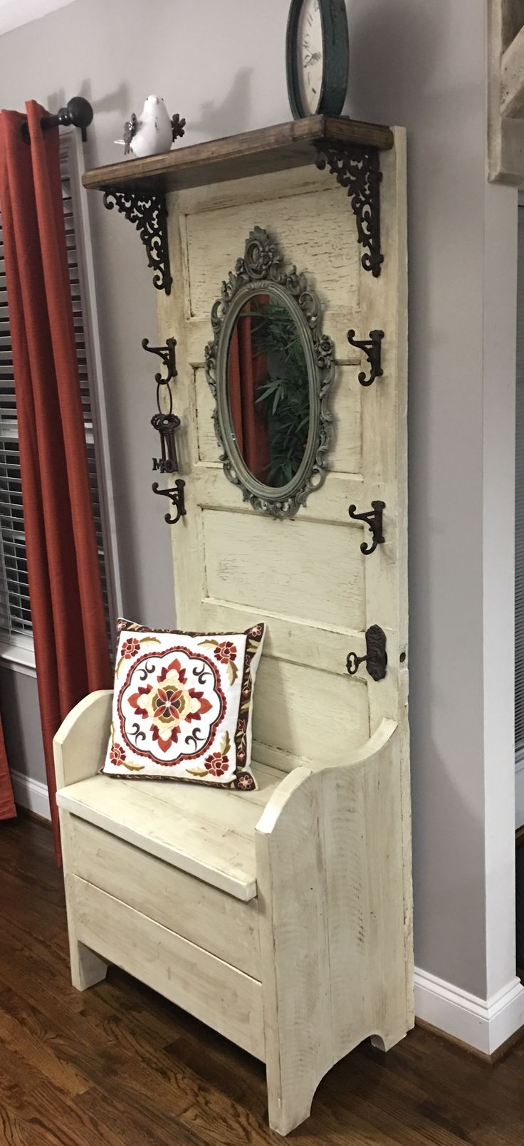 a white bench sitting in front of a mirror on top of a wooden cabinet next to a window