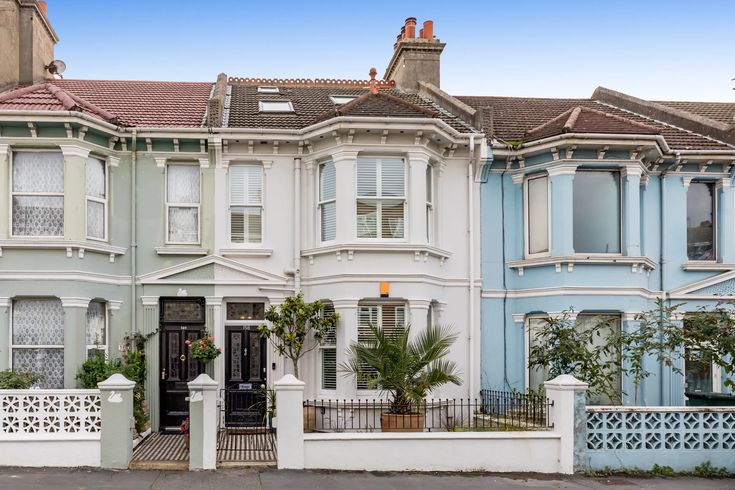 a row of houses with blue and white painted on the front, side by side