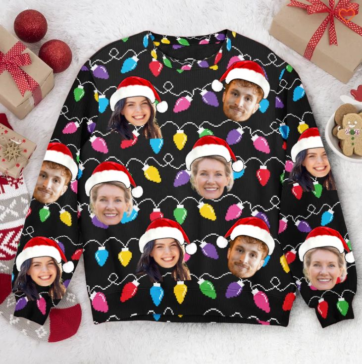 a christmas sweater with the faces of two people wearing santa hats and lights on them