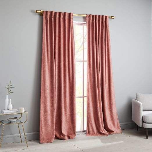 a pink curtain hanging in front of a window