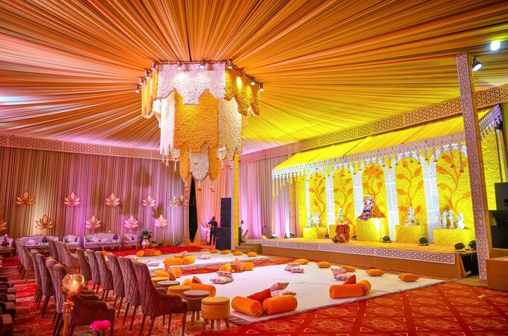 a banquet hall with tables and chairs set up for a formal function in orange, yellow and white