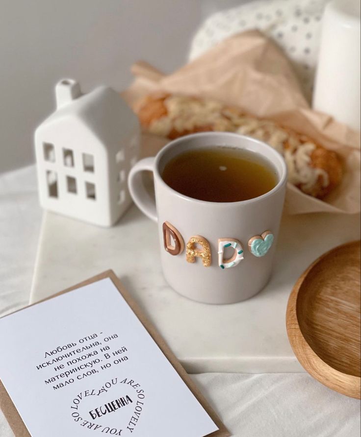 a cup of tea sits next to a note with the word dad written on it