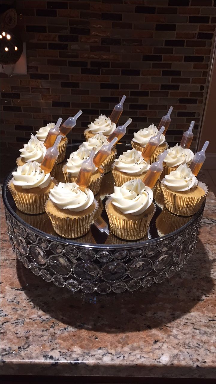 cupcakes with white frosting in a glass bowl on a marble counter top