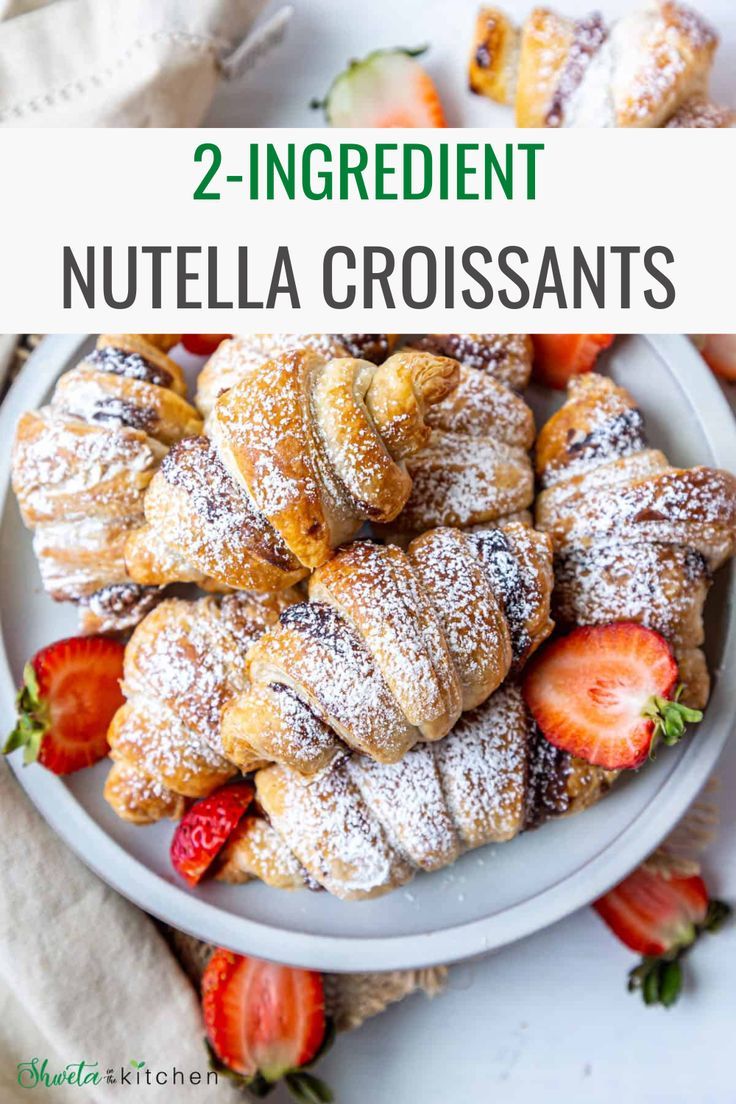 two ingredient nutella croissants on a plate with strawberries and powdered sugar