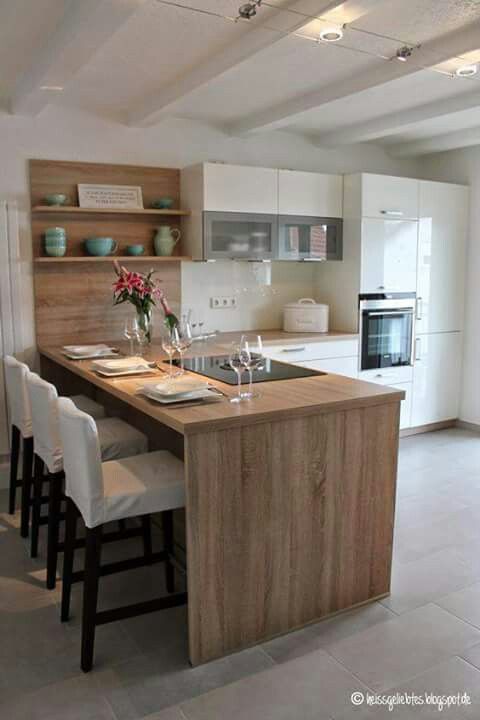 a kitchen with white cabinets and wooden counter tops next to an island in the middle