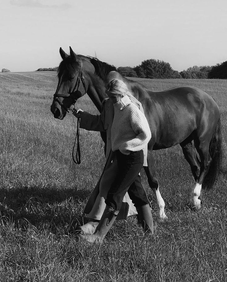 black and white photograph of a woman leading a horse