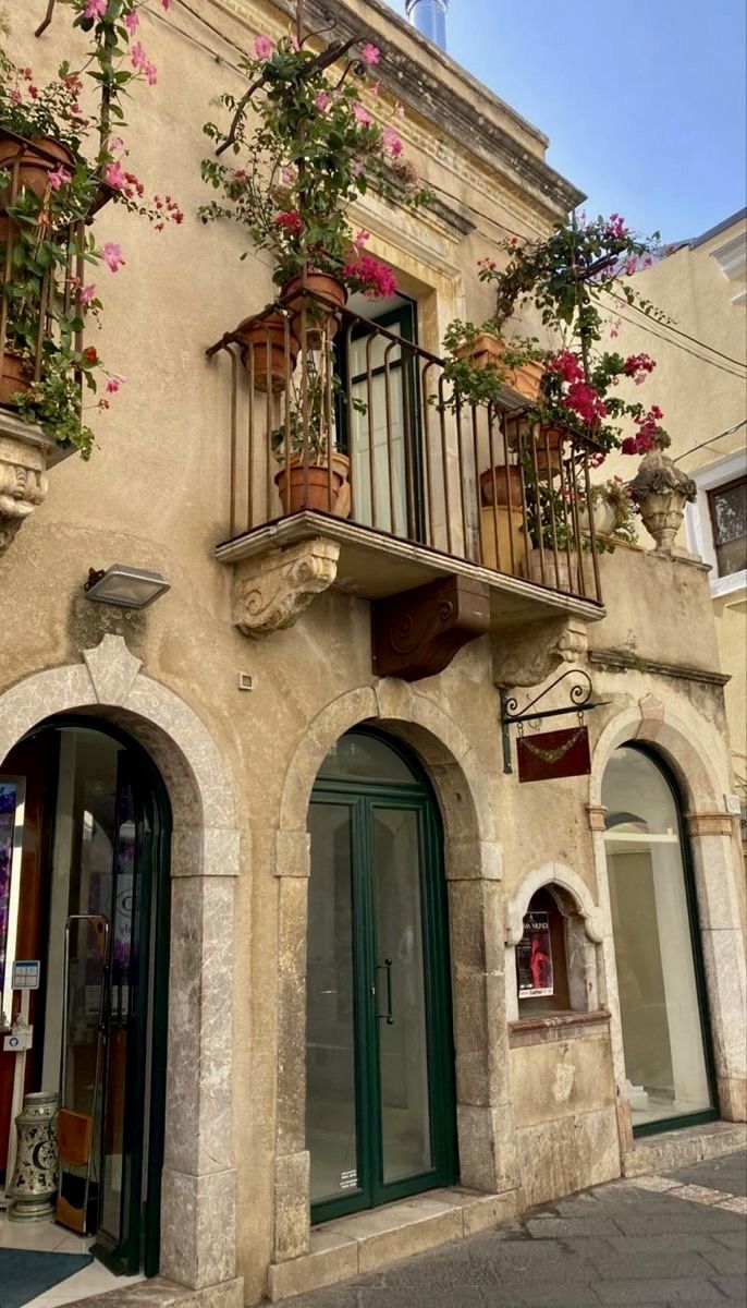 an old building with flowers on the balconies