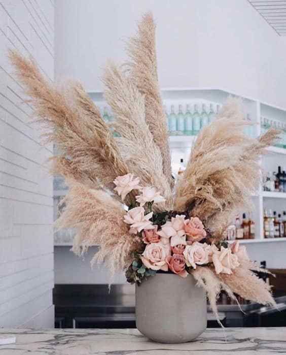 a vase filled with lots of flowers on top of a counter