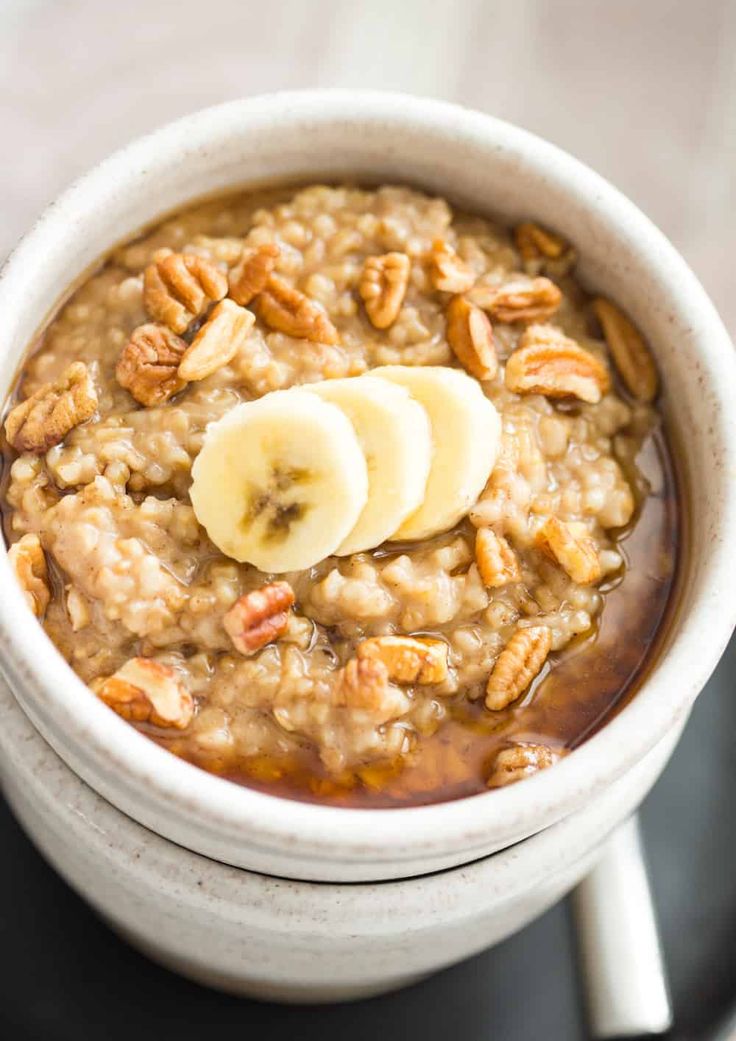 a white bowl filled with oatmeal topped with banana slices