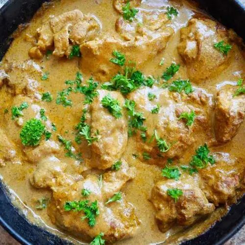 a pan filled with meat and gravy on top of a table