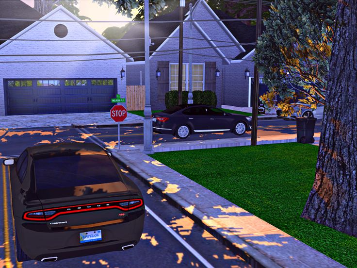 a car is driving down the street in front of a stop sign and some houses