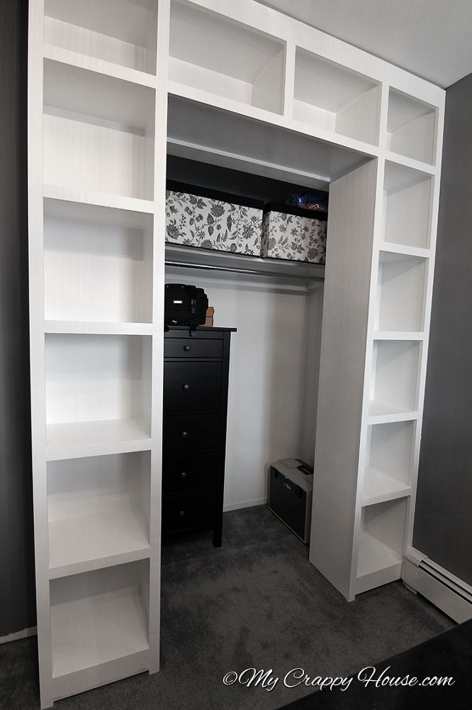 a white bookcase with shelves and drawers in a room that has carpeted flooring