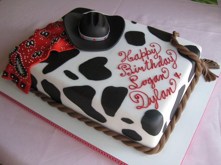 a square cake decorated with black and white cow print